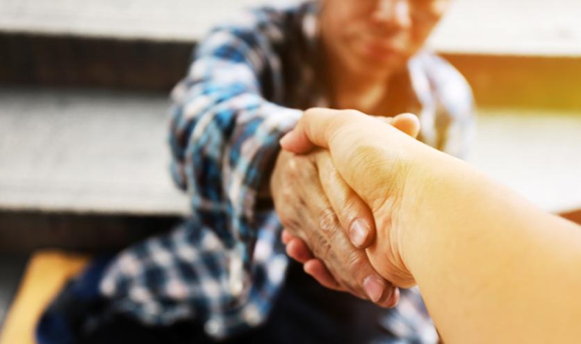 Person Reaching Out to Homeless